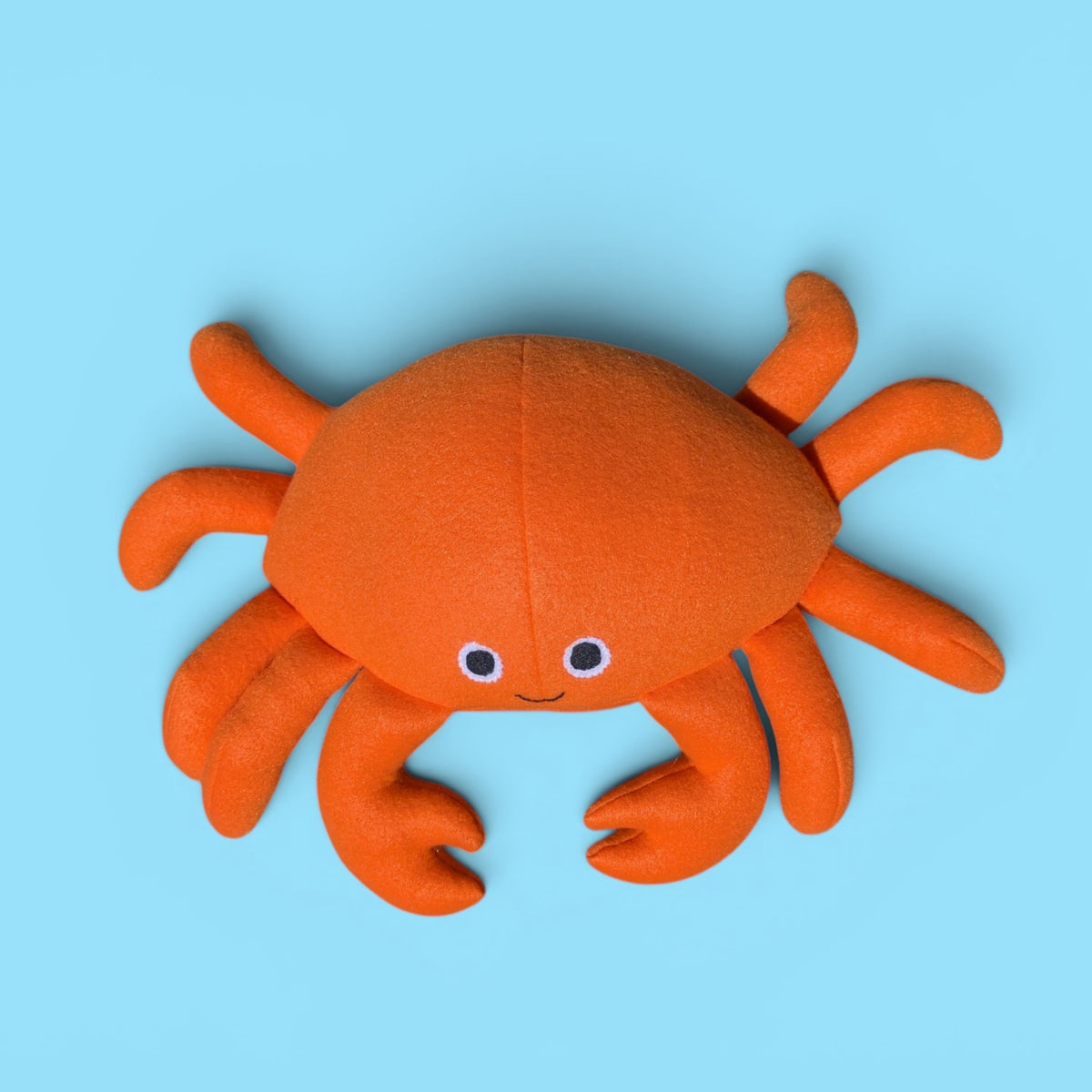 Orange fleece crab stuffed animal photographed from the top.