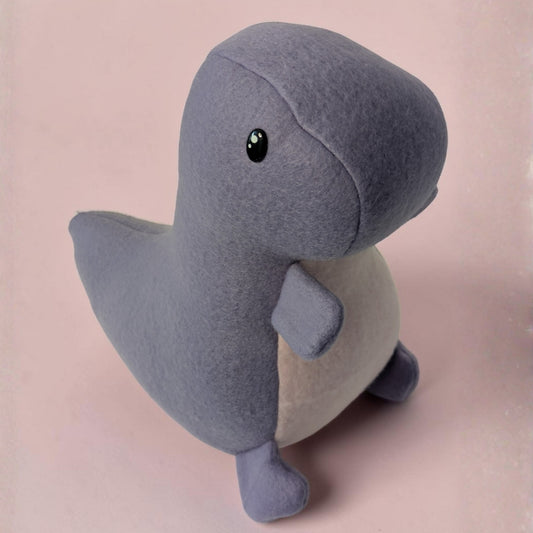 A plush dinosaur toy made of soft purple fleece fabric with a light pink underside, standing against a solid pale pink background.