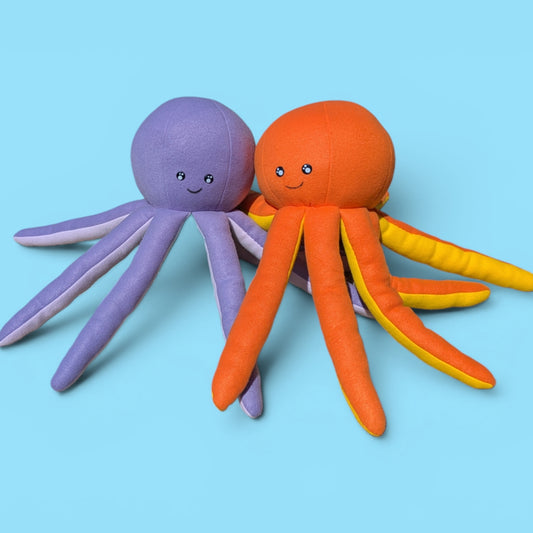 Two plush octopus toys on a light blue background. One octopus is lavender purple with pale pinkish-purple tentacles, and the other is bright orange with yellow underbelly and orange tentacles.