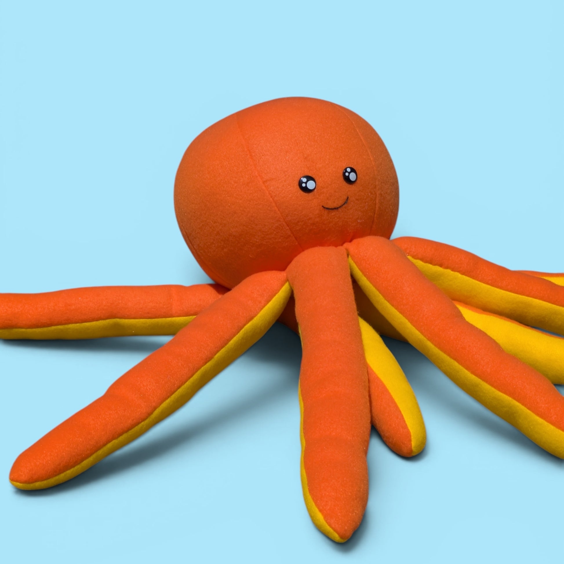 A sideview of an orange octopus fleece stuffed animal toy 