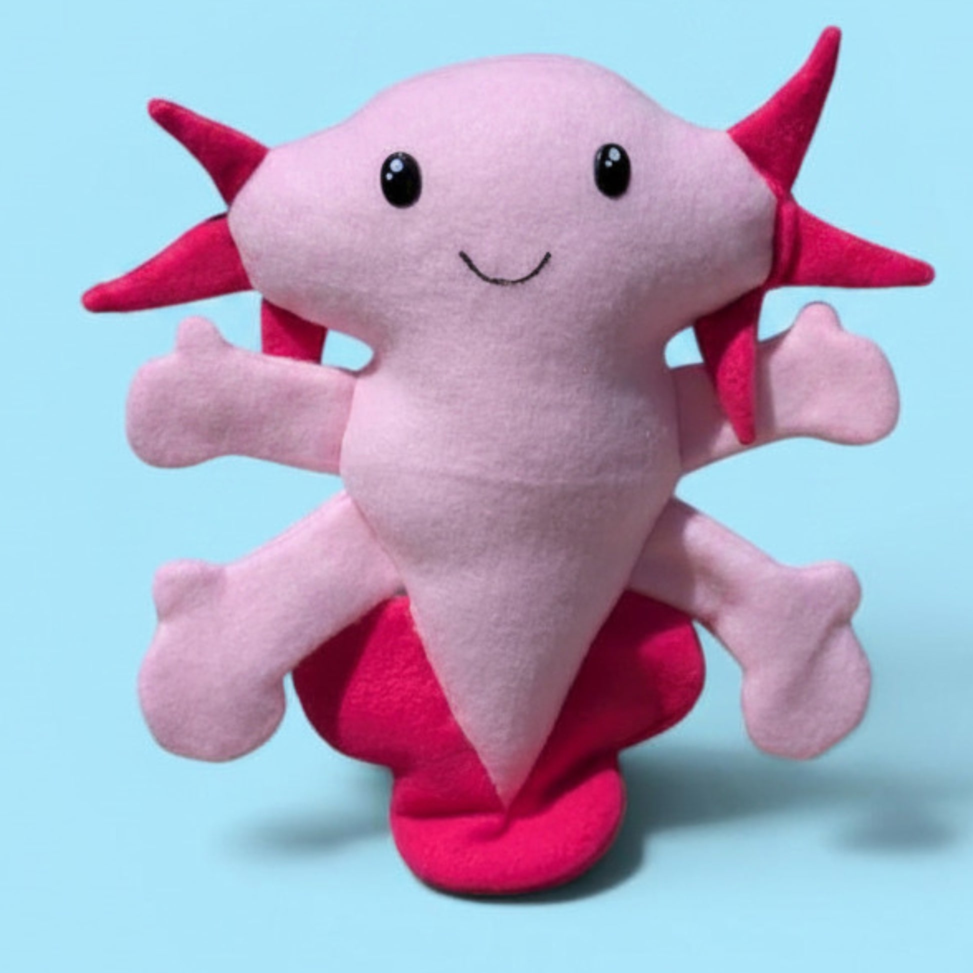 A plush fleece axolotl stuffed animal with light pink body and arms and hot pink gills and fins