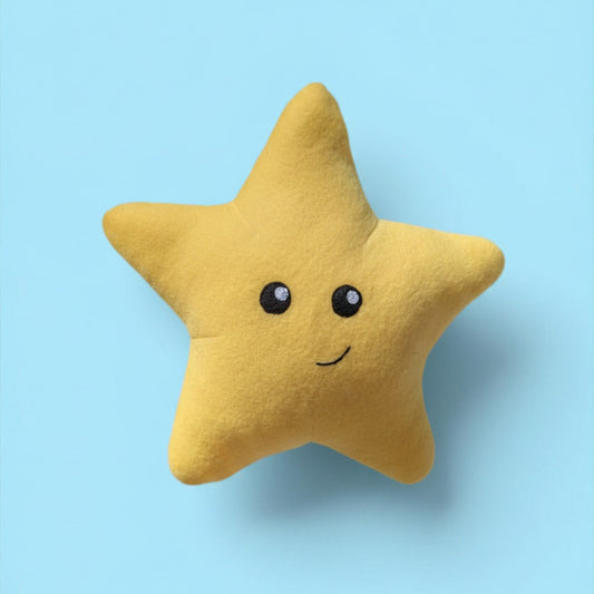 A yellow star-shaped plush pillow with black felt eyes and a smiling mouth, centered on a light blue background.