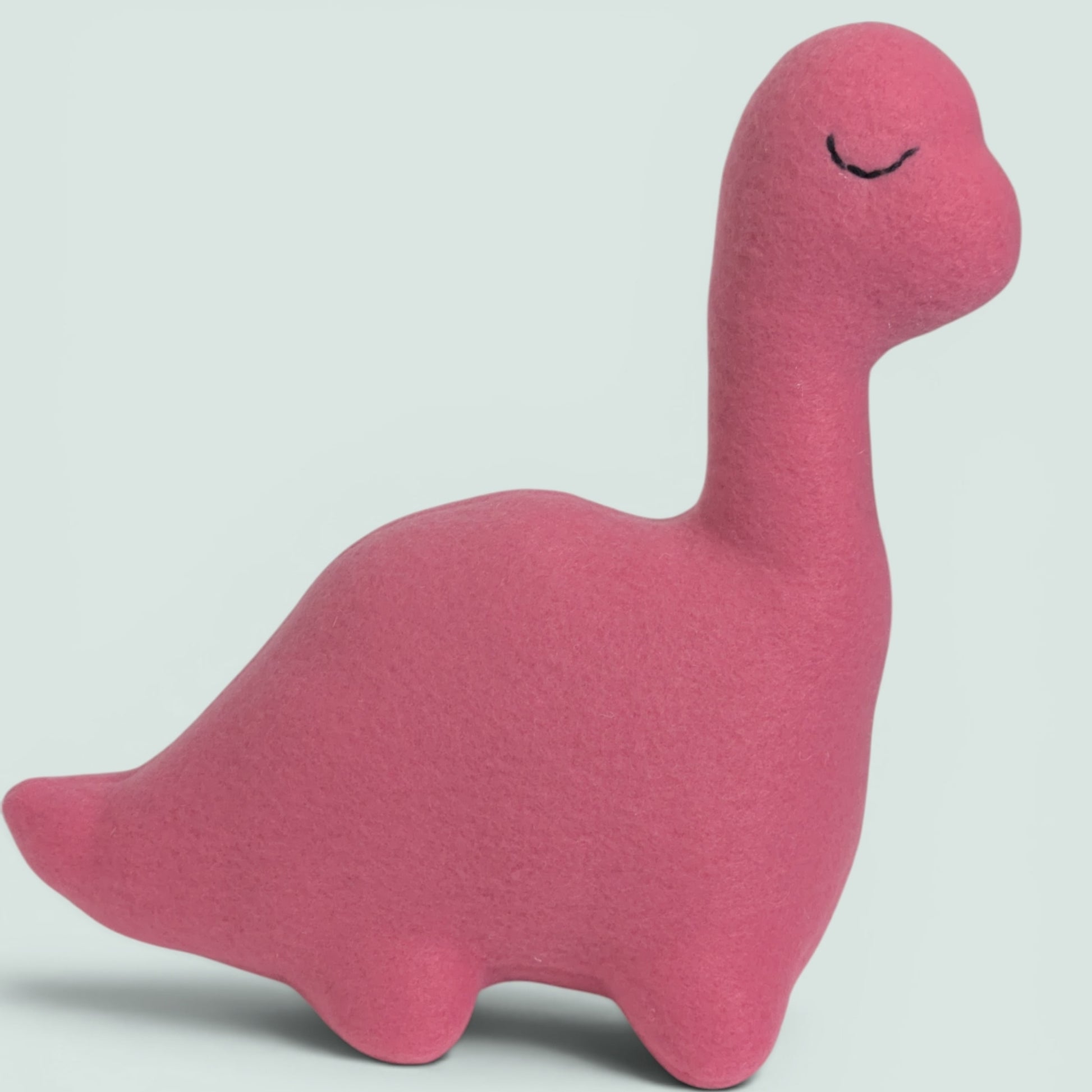 A pink fleece dinosaur toy with a long neck and closed embroidered eyes, shown on a light gray background.