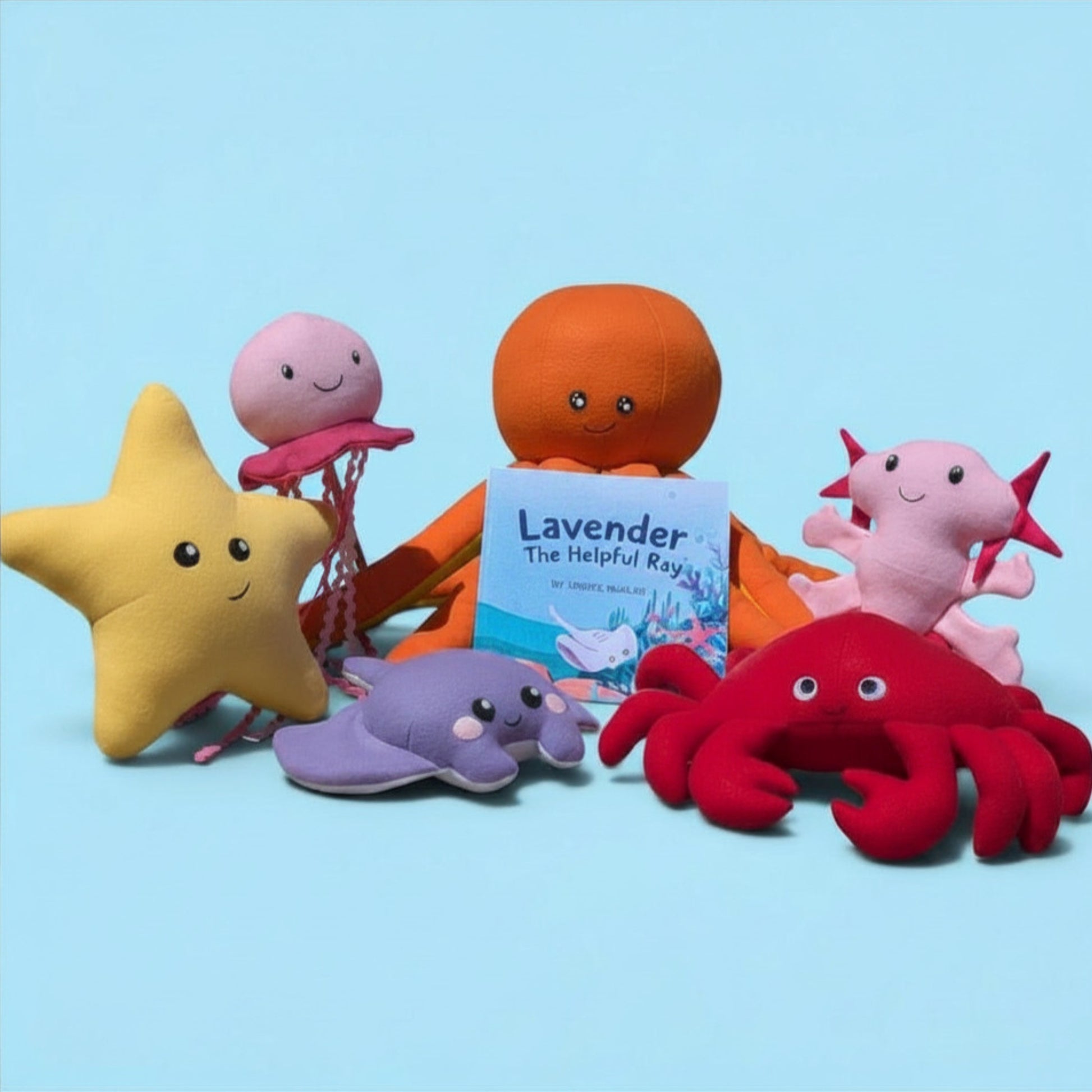 A group of colorful plush sea-themed toys and a children's book on a light blue background. The set includes a yellow starfish, a pink jellyfish, an orange octopus holding a book titled 'Lavender The Helpful Reef', a purple stingray, a red crab, and a pink axolotl.